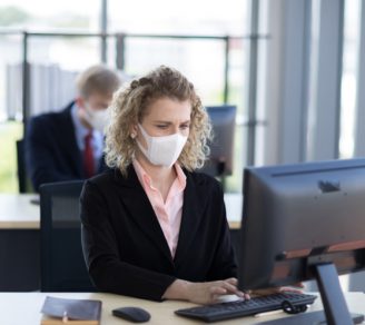 Employees wearing facemasks in an office setup