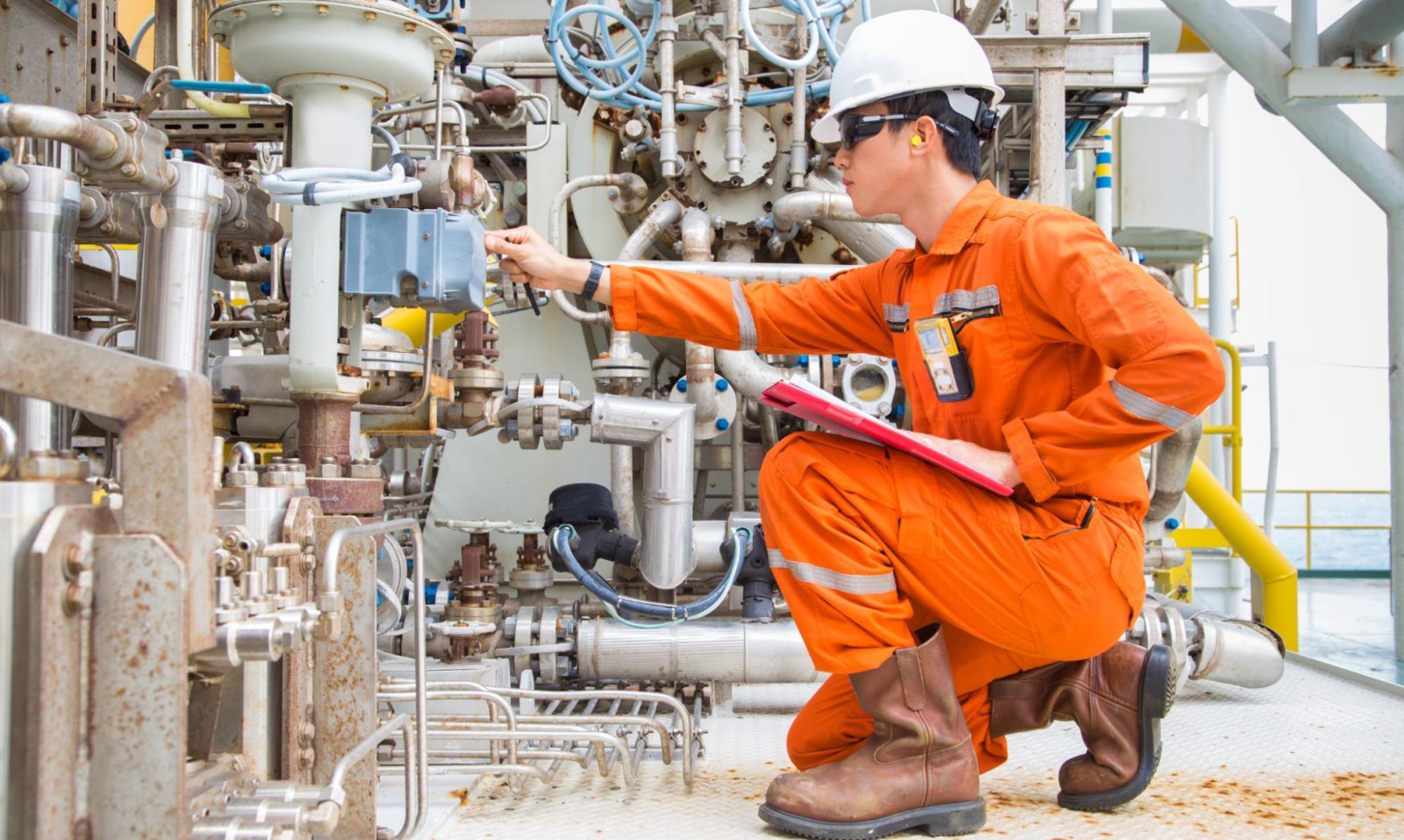 A mechanical engineer, who is protected by engineering insurance, running a maintenance check