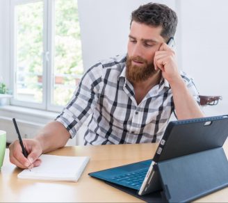 An independent contractor taking notes at home while on a phone call