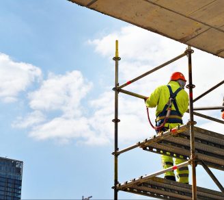 Two construction workers on scaffolding, covered by scaffolding insurance