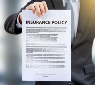 A man holding up an insurance policy that contains an insurance warranty clause