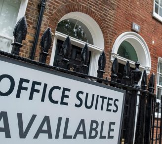 Close up of a sign on a commercial property saying “Office Suites Available”