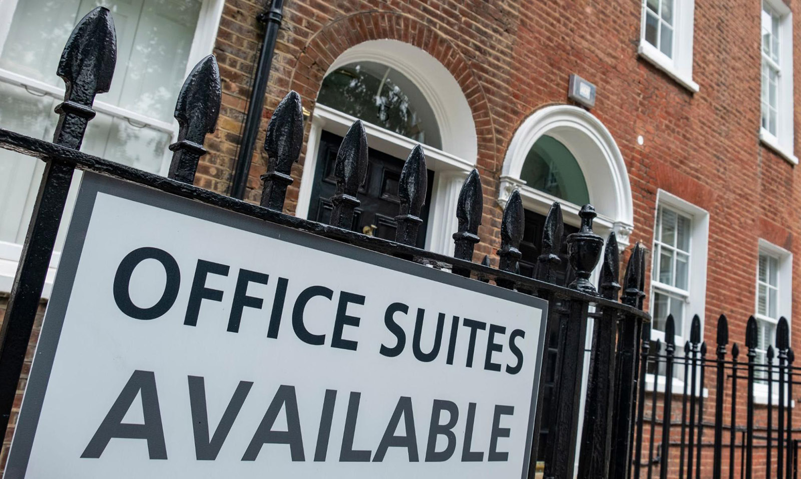 Close up of a sign on a commercial property saying “Office Suites Available”