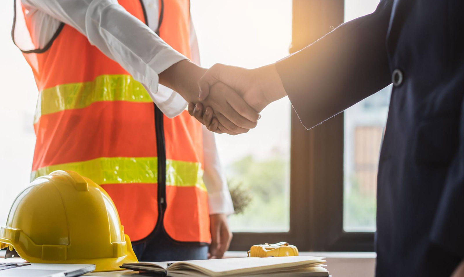 An insurance broker shakes hands with a contractor