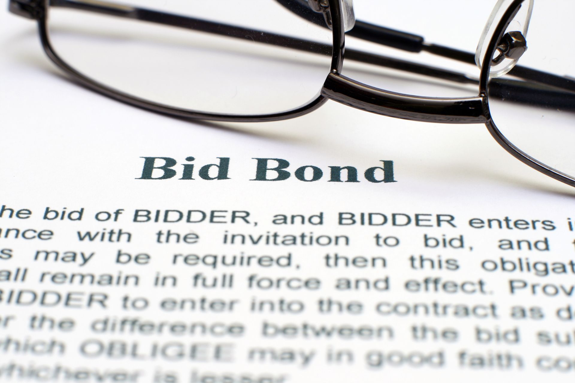 A close-up of a bid bond contract and a pair of glasses