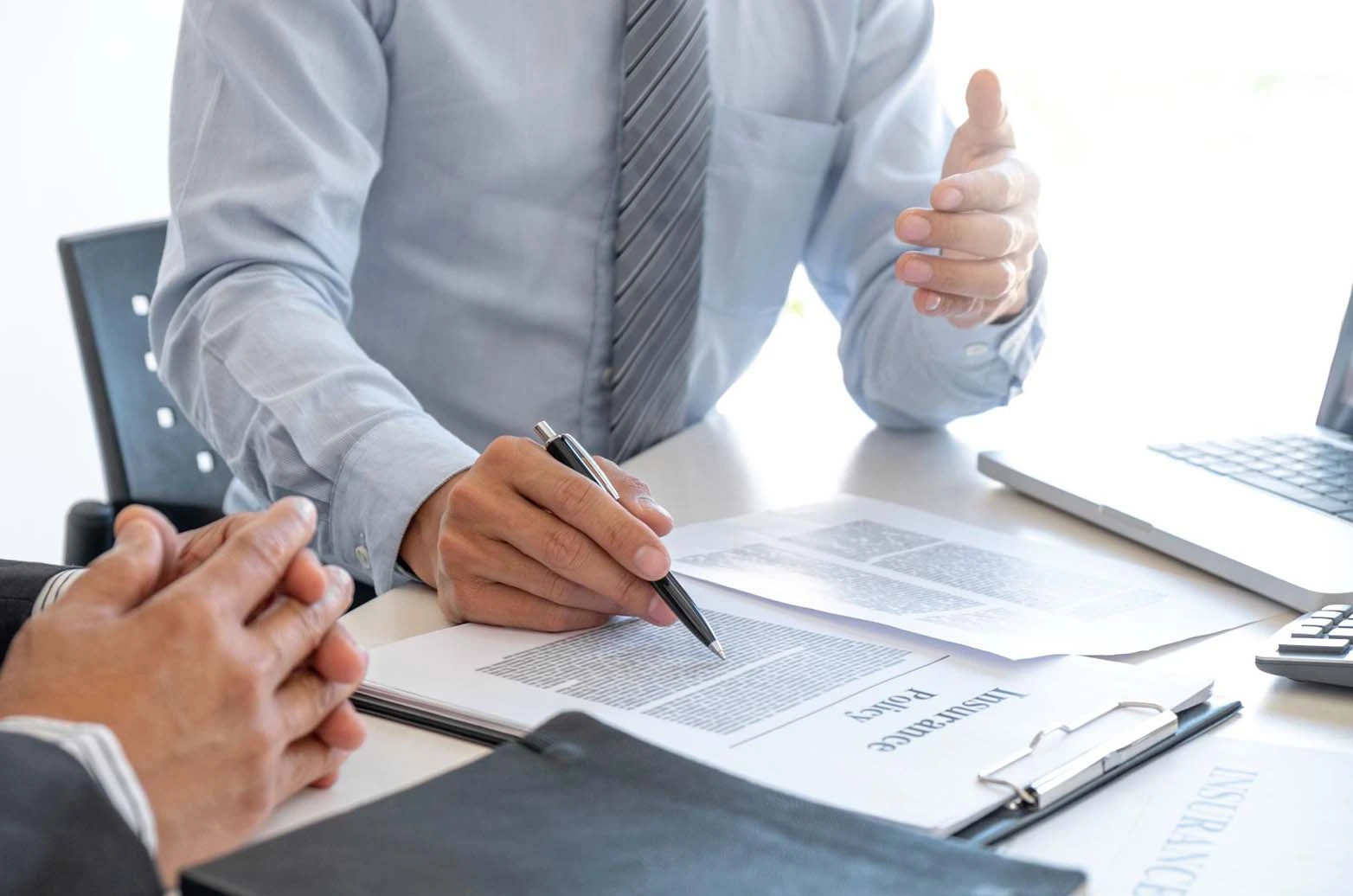 An insurance broker explaining an insurance policy’s terms to a client