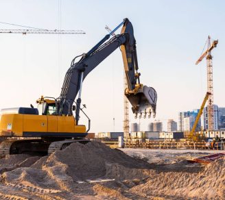 Cranes and an excavator in an industrial construction site