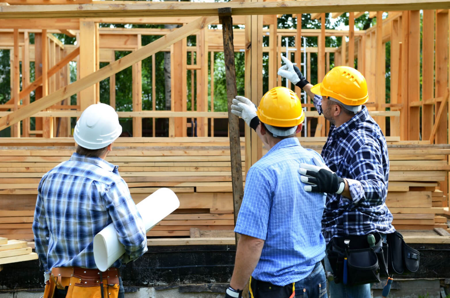 Construction workers working the wooden frame of a house