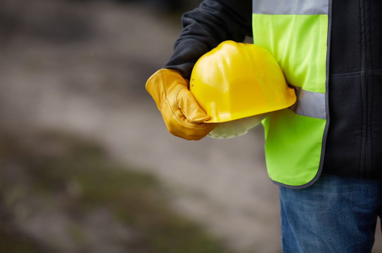 A contractor holding their yellow hard hat