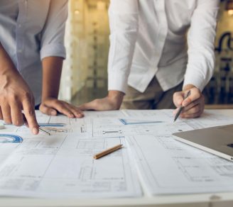Two building contractors inspecting design plans