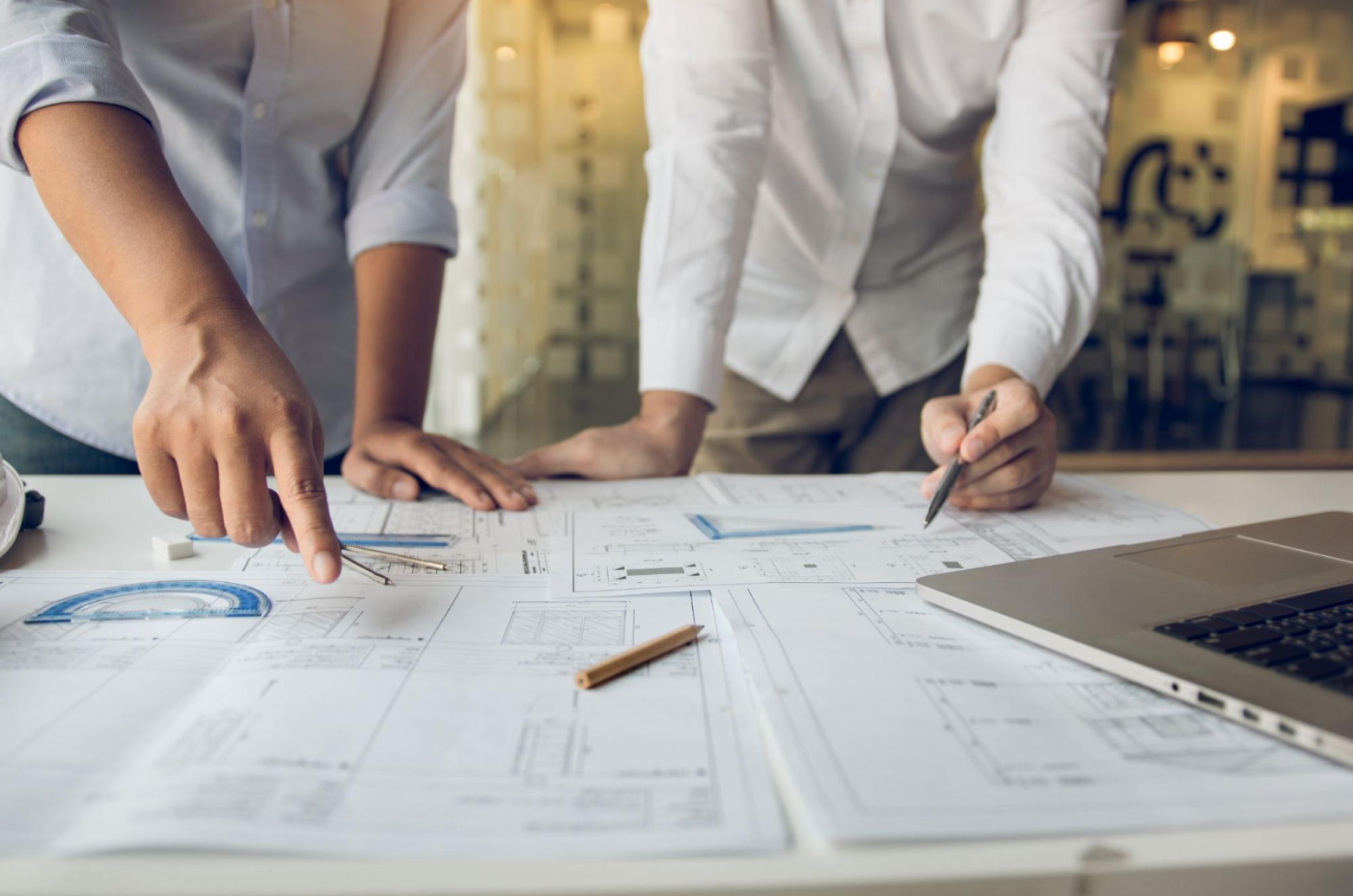 Two building contractors inspecting design plans