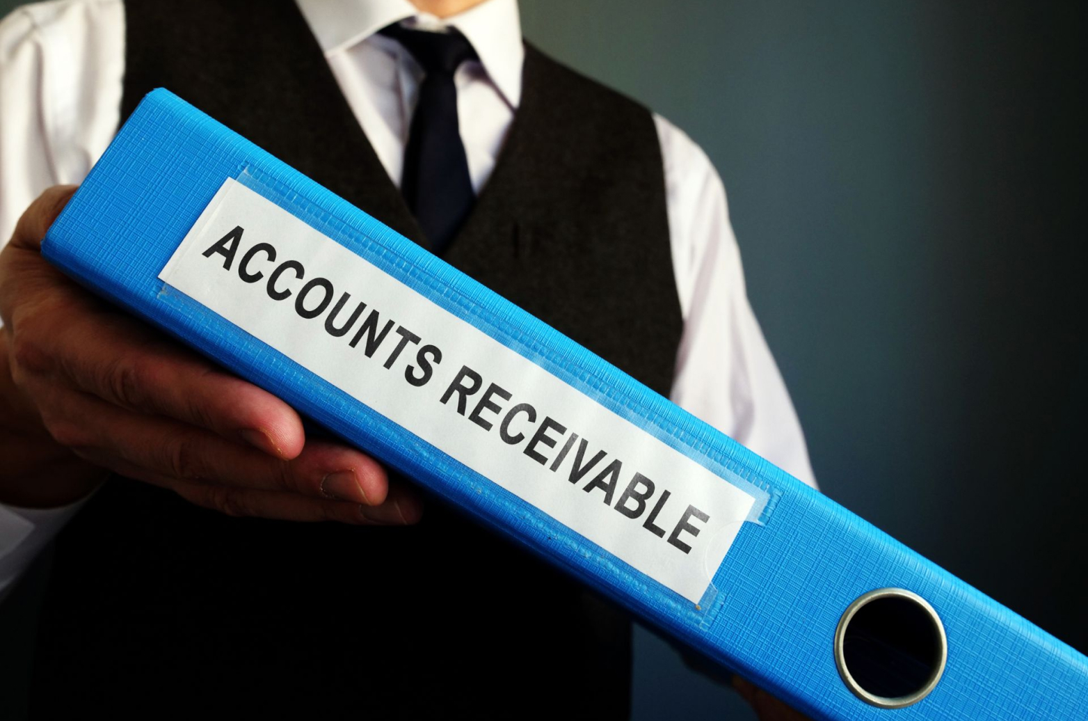 Person holding an AR collection binder labelled “Accounts receivable”
