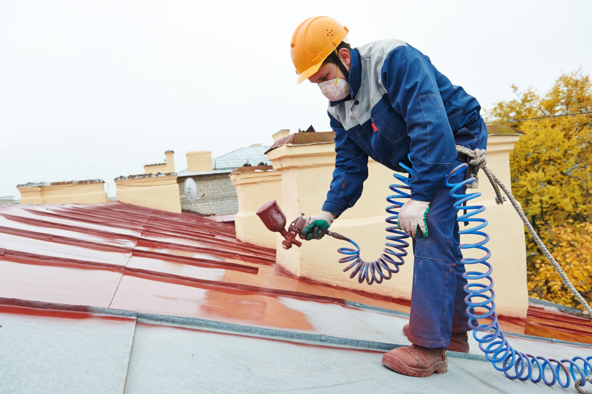 Ontario Painting Contractors Association member painting roof with airbrush