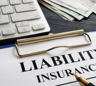 The words liability Insurance printed on paper, a keyboard in the background