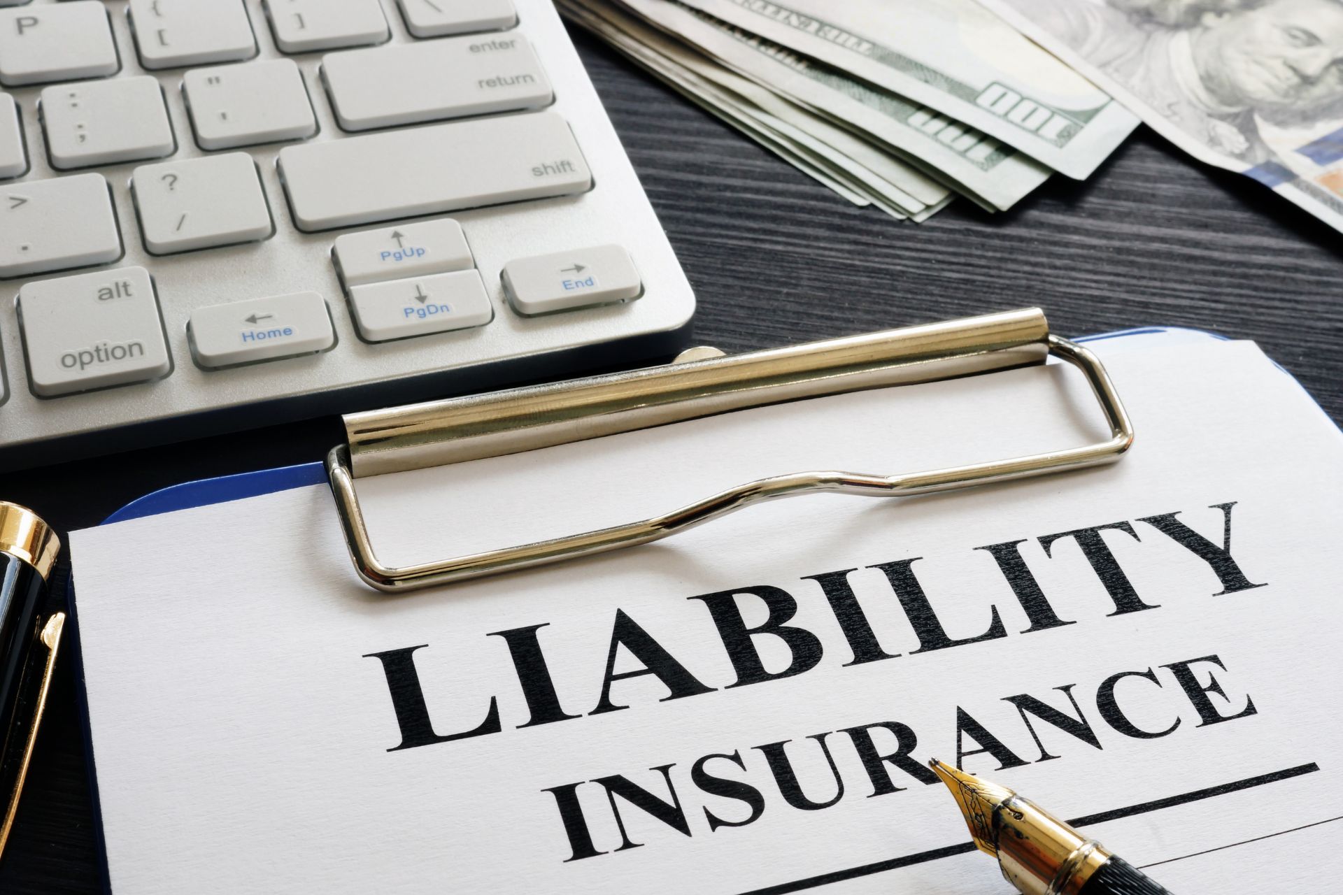 The words liability Insurance printed on paper, a keyboard in the background