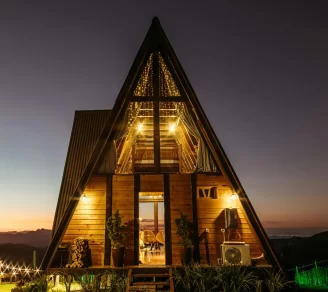 An A-Frame cottage with a mountain terrain background.