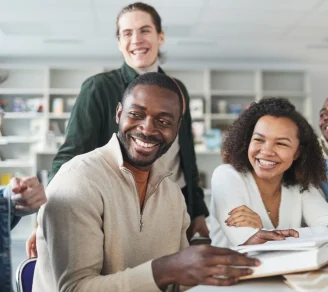 A group of modern employees sit smiling in a common area